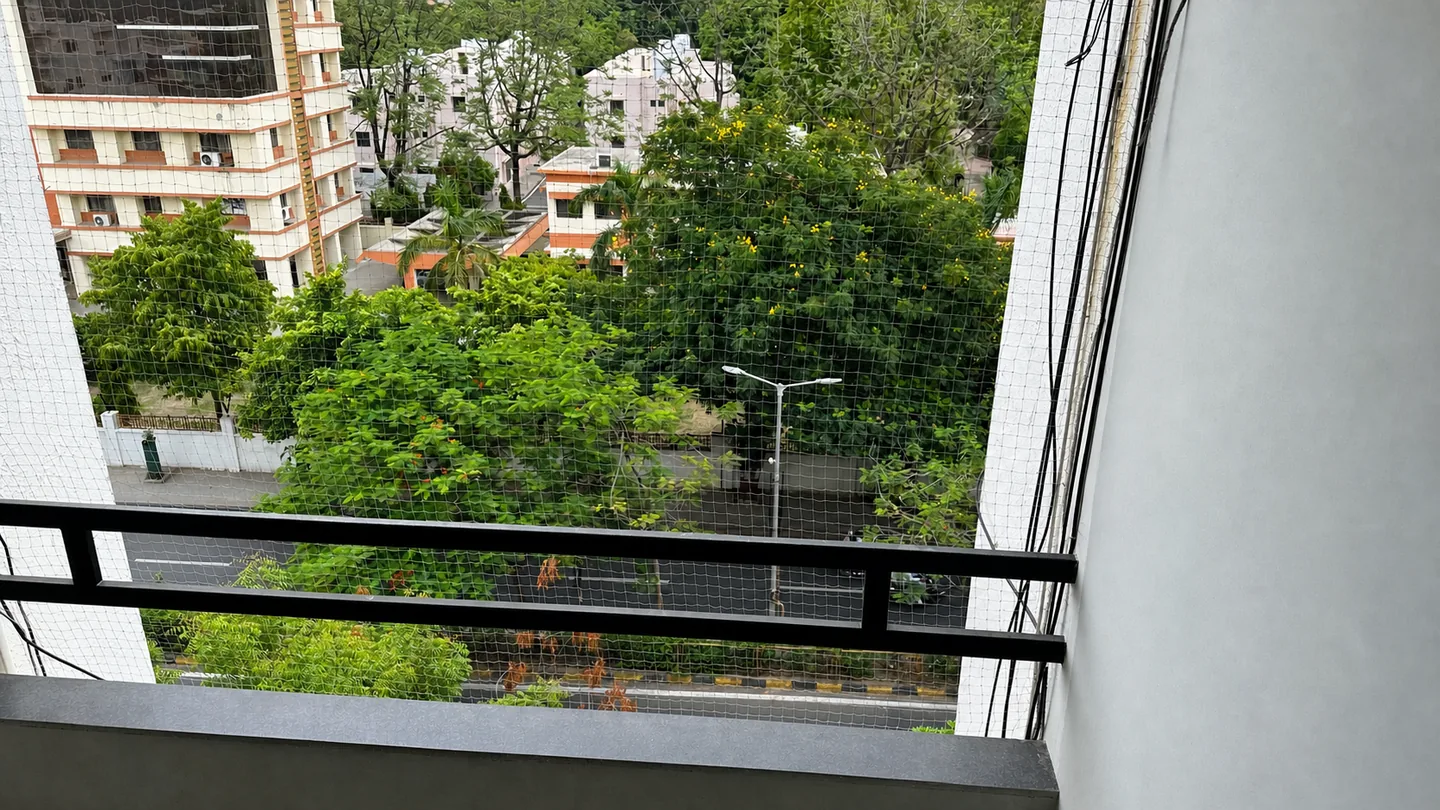 Green treetops and nearby buildings seen from the PJ PG balcony