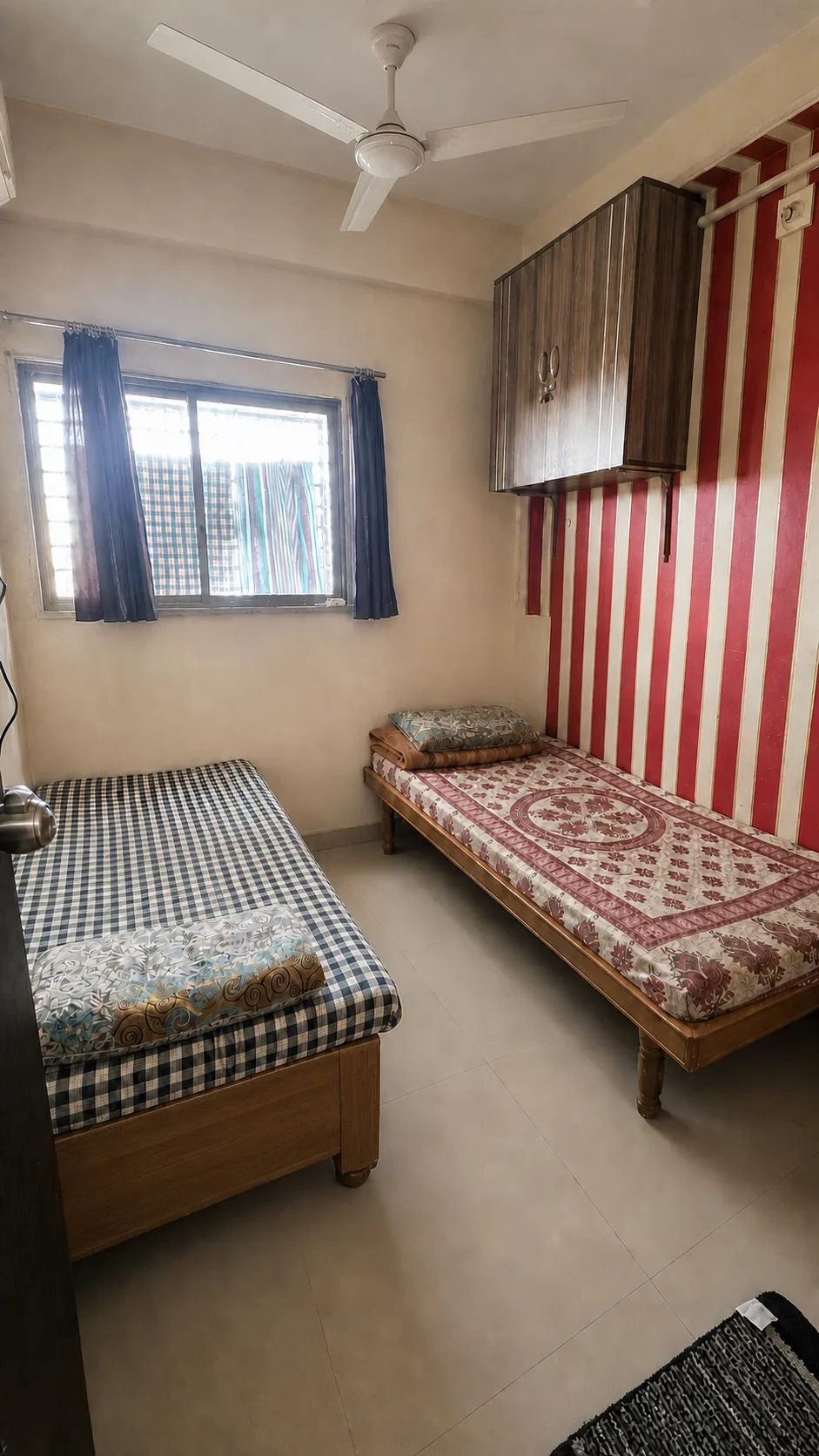 Two-bed room with polished wooden frames and a maroon striped wall